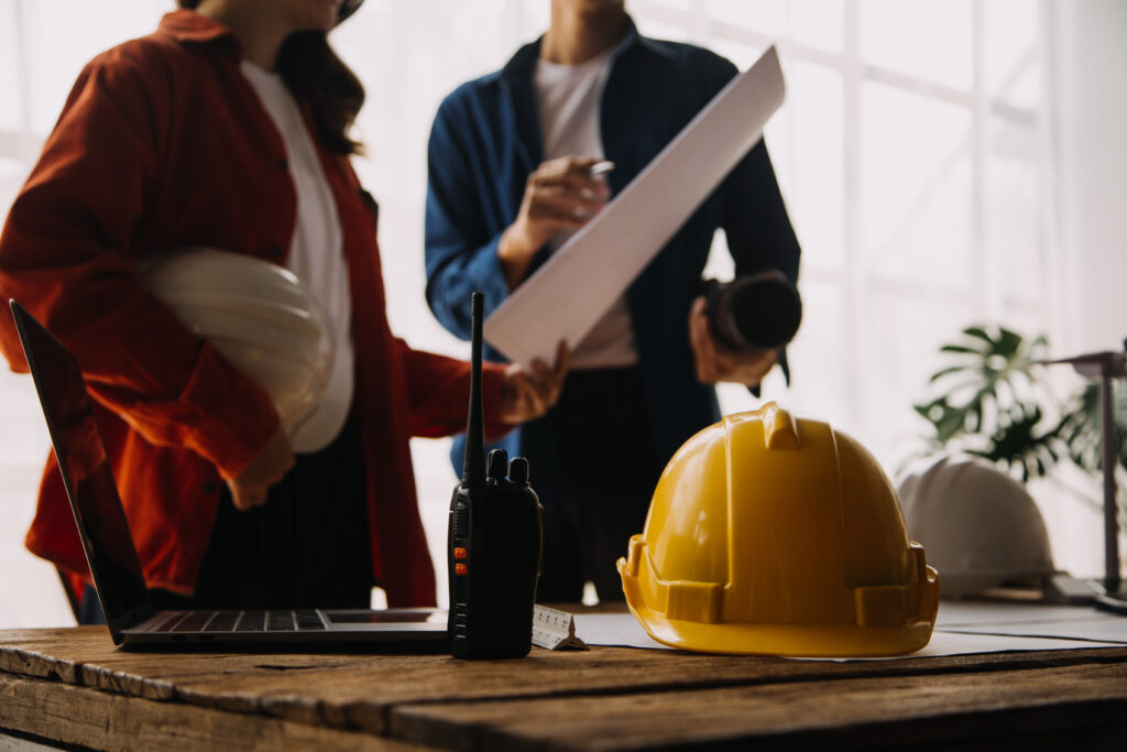 Construction planning with hard hats and laptop.