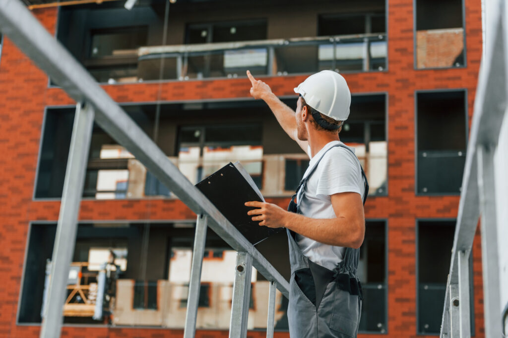 Construction worker inspecting building site progress.