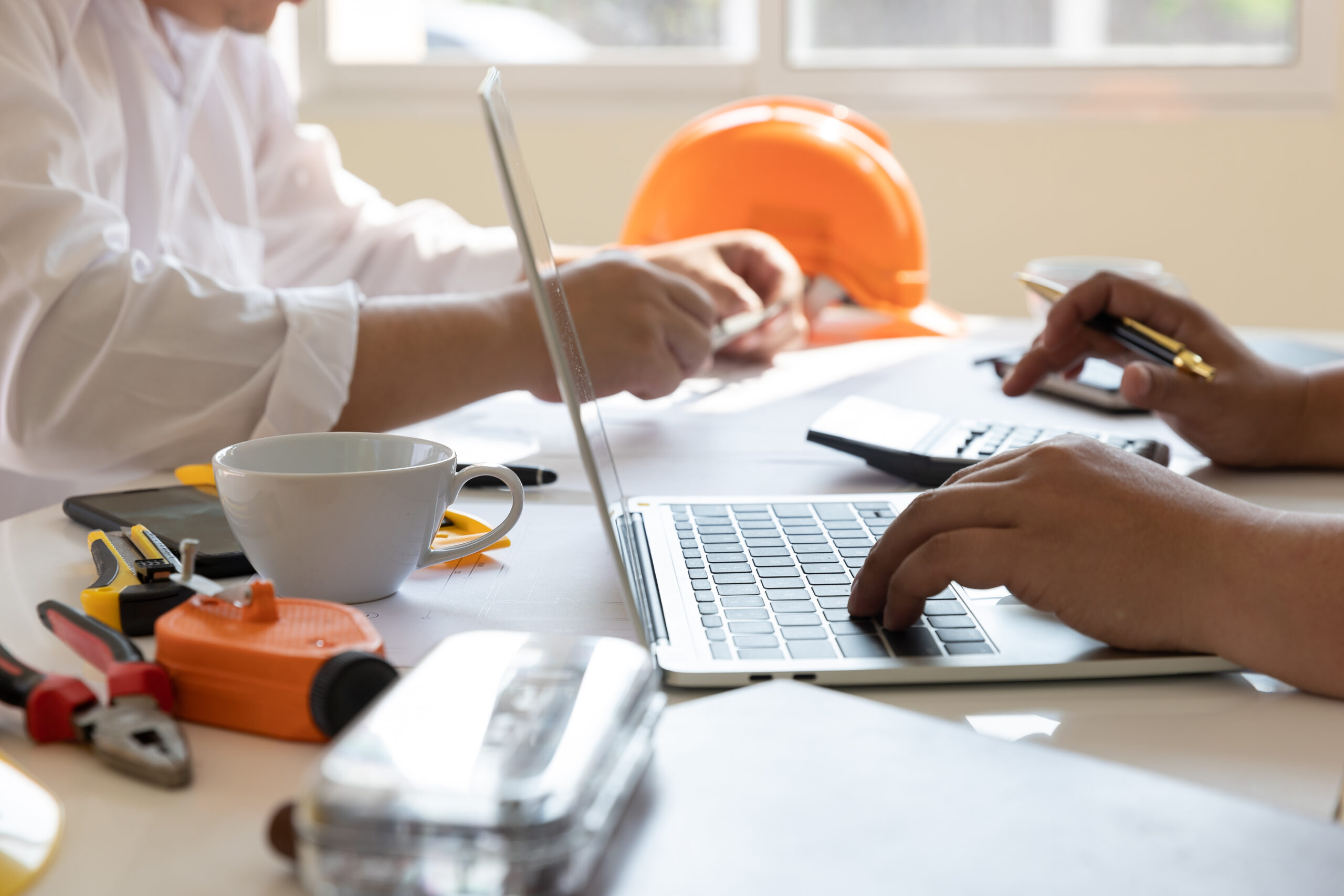 People working on construction project with laptop.