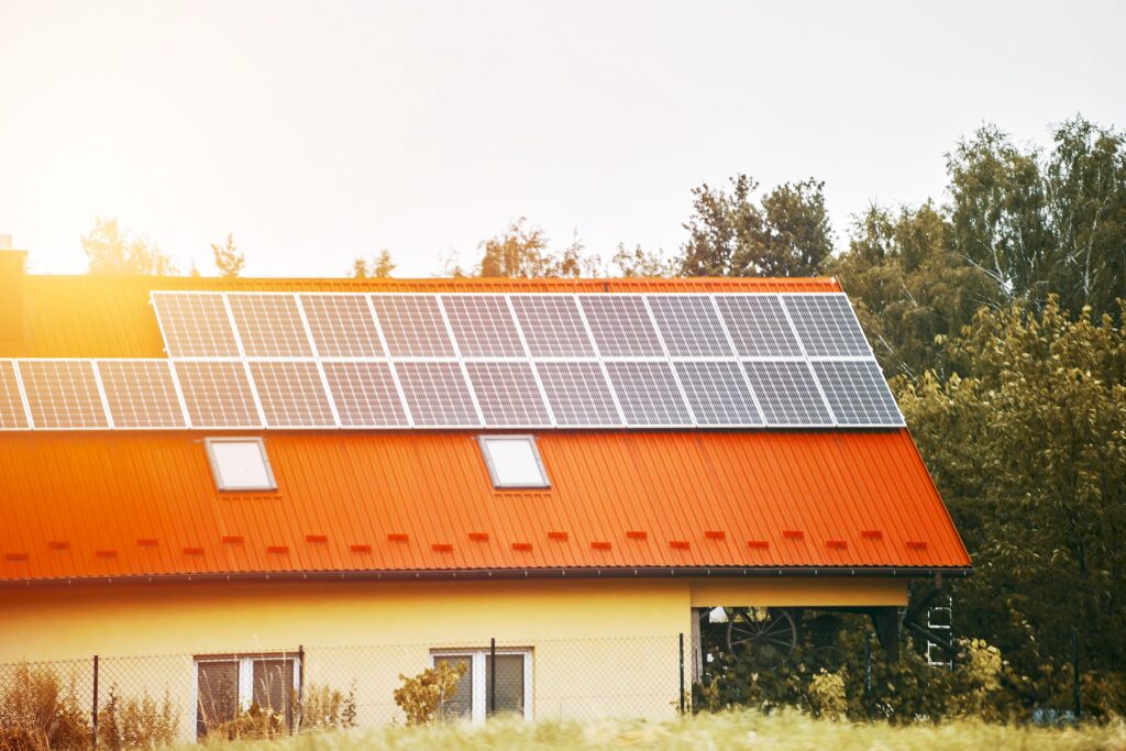 Solar panels mounted on red house roof